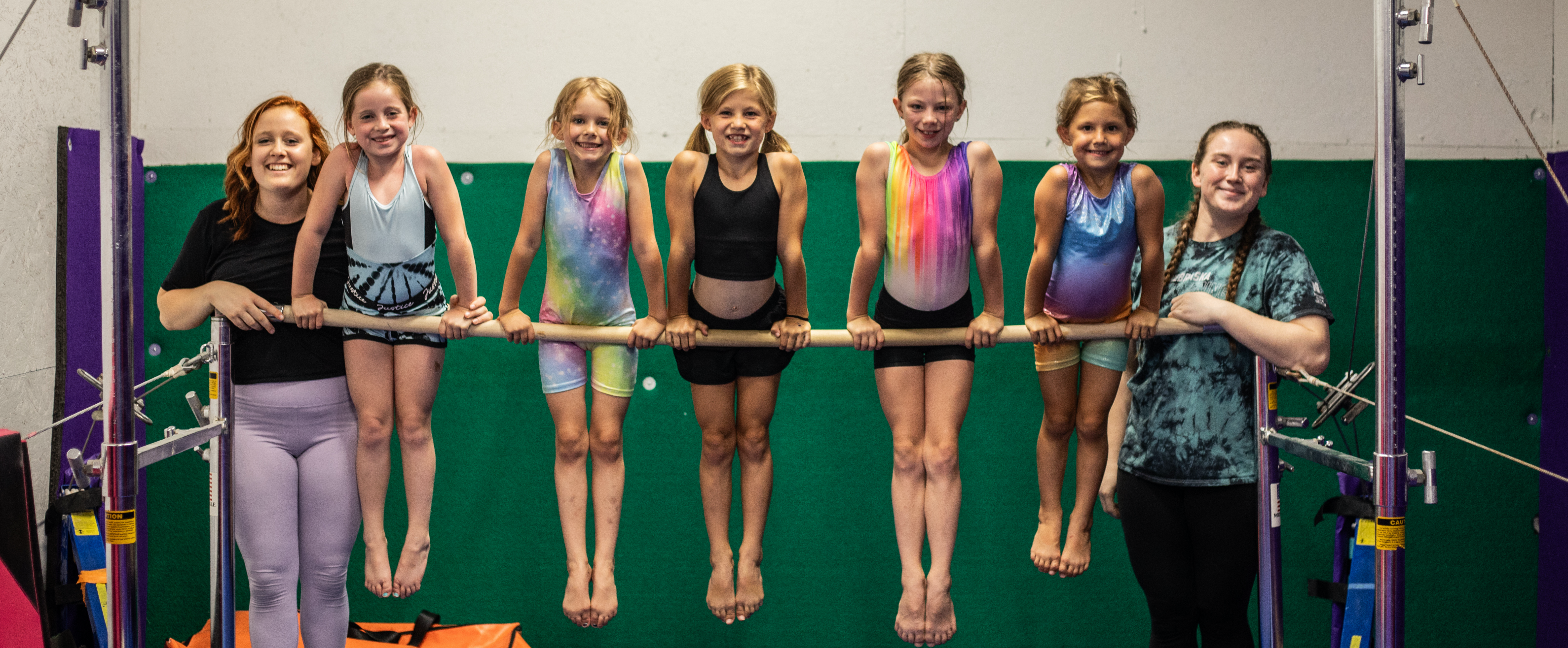 gymnasts balancing on bar